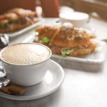 カプチーノとクロワッサンサンドの朝食